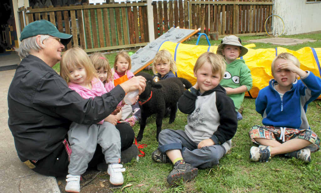 Playgroup crew Lyn, Taylor, Amy, Lauren, Calum, Denovan, Bella and Riley play with Polly the Lamb.